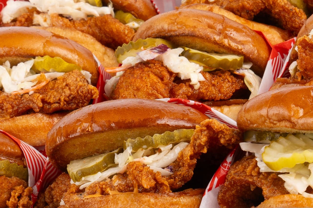 Stacked Nashville hot chicken sandwiches with pickles and slaw
