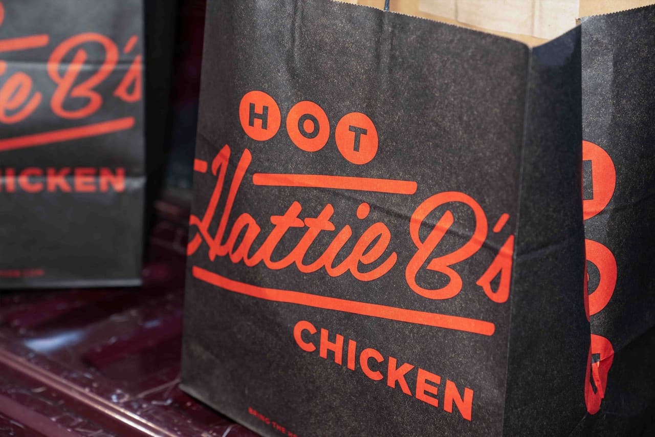 Branded Hattie B's takeout bags ready for pickup and catering orders