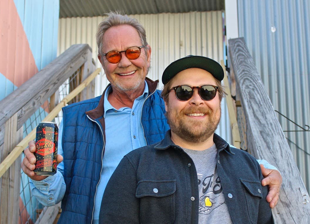 Two of the founders smiling on an outdoor stairway